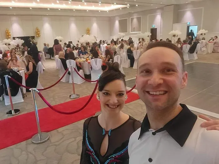 Dance couple taking a selfie on a red carpet at a banquet hall during Ottawa dance workshops and performances by DQ Ballroom & Fitness