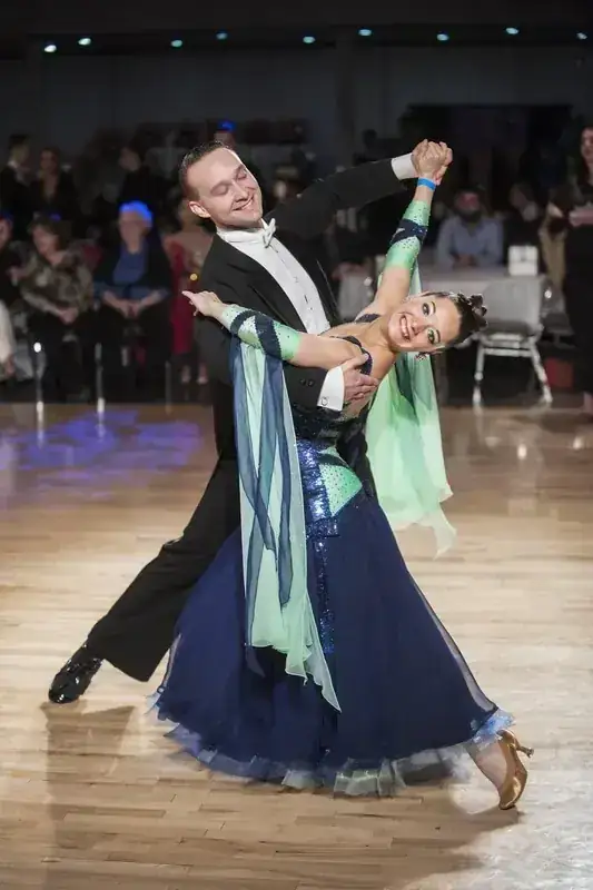 Couple in a deep dip in blue and green ballroom dresswear at the DQ Ballroom & Fitness Ottawa dance studio